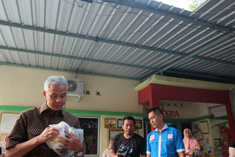 Gubernur Jawa Tengah Ganjar Pranowo membawakan bola untuk anak-anak dengan HIV/AIDS di Yayasan Lentera, Surakarta, Selasa (23/7/2019)