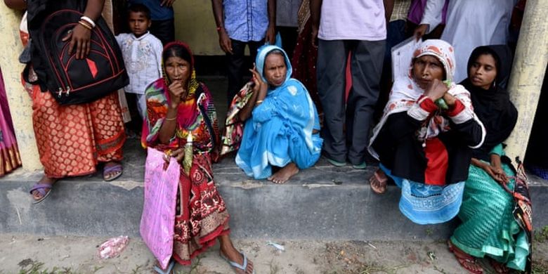 Beberapa warga menunggu untuk melihat rancangan peraturan pencatatan sipil di Negara Bagian Assam, India. Rancangan itu menjadi kontroversial karena menghilangkan kewarganegaraan empat juta penduduknya.