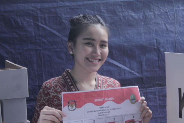 Penyanyi dangdut Ayu Ting Ting menunjukkan kertas suara sebelum menggunakan hak pilih untuk Pilkada Jawa Barat di kediamannya di Depok, Rabu (27/6/2018).