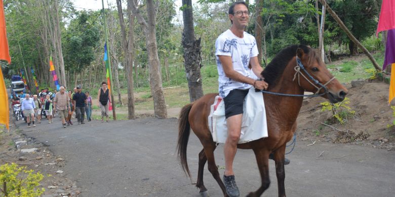 Seorang turis Italia menunggang kuda dalam tradisi penjemputan tamu dengan tradisi berkuda dari Rongga, Rabu (15/8/2018).