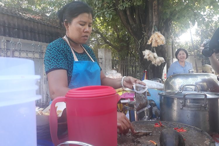 Ibu Mella, penjual rujak cingur seharga Rp 60.000 di Wiguna Timur, Kelurahan Gunung Anyar, Kecamatan Rungkut, Surabaya, melayani pembeli, Rabu (12/6/2019). 
