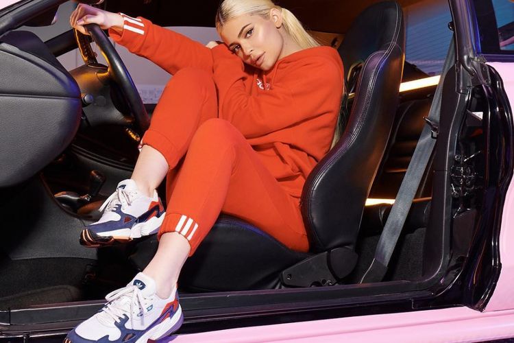 Kylie Jenner mengenakan busana retro sport dengan sneakers Adidas Falcon