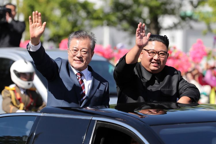 Pemimpin Korea Utara Kim Jong Un (kanan) dan Presiden Korea Selatan Moon jae-in melambaikan tangan menyapa warga di Pyongyang Selasa (18/9/2018). Moon memulai kunjungan selama tiga hari dengan denuklirisasi menjadi agenda utama.