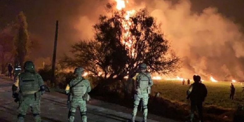 Tentara melihat kobaran api dari pipa minyak ilegal yang meledak di Tlahuelilpan, Meksiko, pada Jumat (18/1/2019).