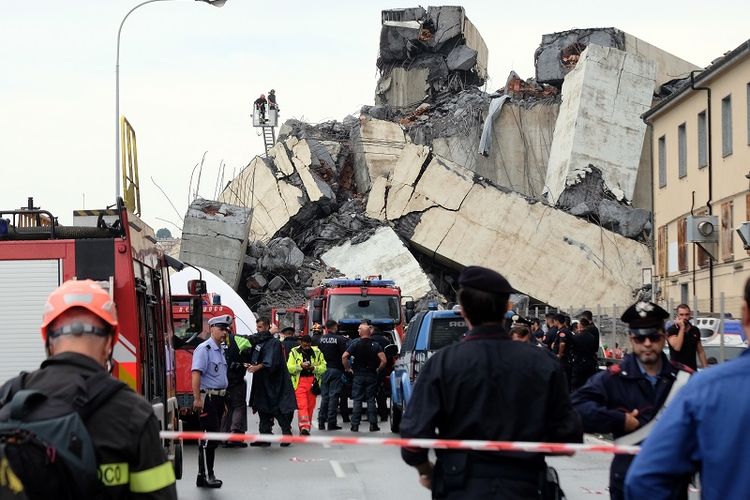 Tim penyelamat sedang menyisir lokasi yang tertimpa potongan beton bagian dar Jembatan Morandi di Genoa, Italia yang ambruk pada Selasa (14/8/2018) pagi. 