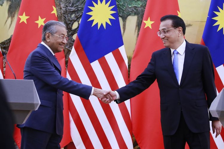 PM Malaysia Mahathir Mohamad menjabat tangan PM China Le Keqiang usai menggelar jumpa pers di Beijing, Senin (20/8/2018).