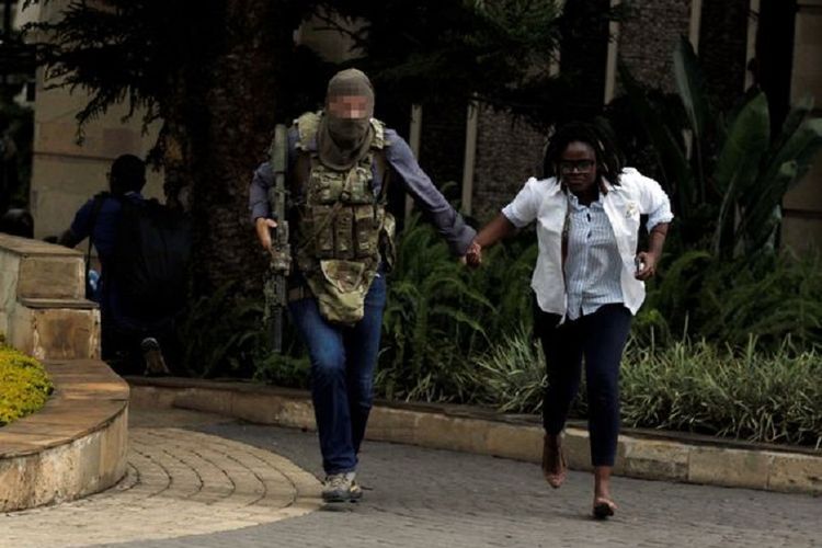 Seorang anggota pasukan elite Inggris SAS berlari bersama warga sipil ketika terjadi penyerangan di kawasan hotel mewah di Nairobi, Kenya, pada Selasa (15/1/2019).