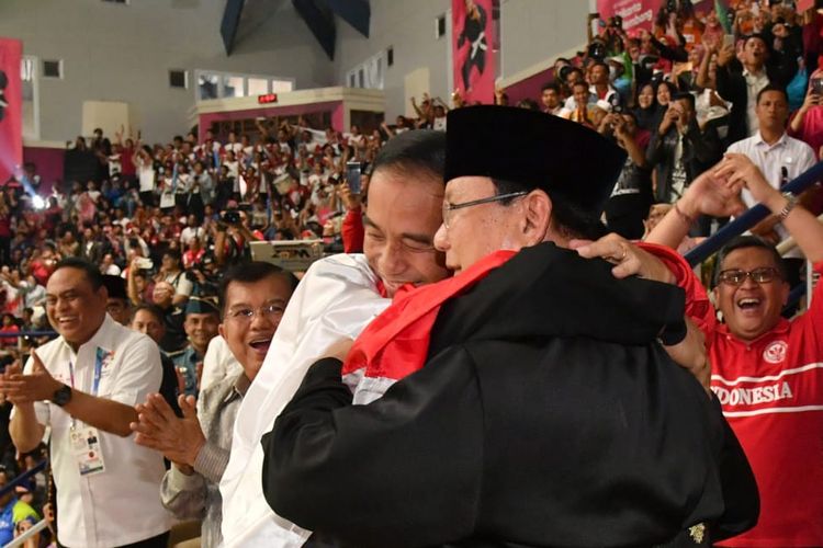 Presiden Joko Widodo dan Ketua Umum PB IPSI Prabowo Subianto bersama-sama memeluk atlet pencak silat putra Indonesia Hanifan Yudani Kusuma di Padepokan Pencak Silat, Taman Mini Indonesia Indah, Jakarta, Rabu (29/8/2018).