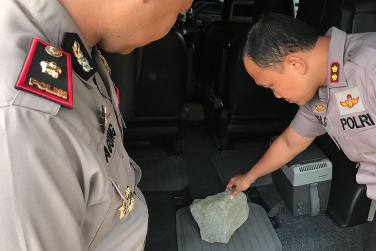 Penampakan batu besar yang dilempar dan menembus kaca mobil di Tol Jakarta-Merak, Rabu (27/6/2018). (Dokumentasi Polres Serang) 
