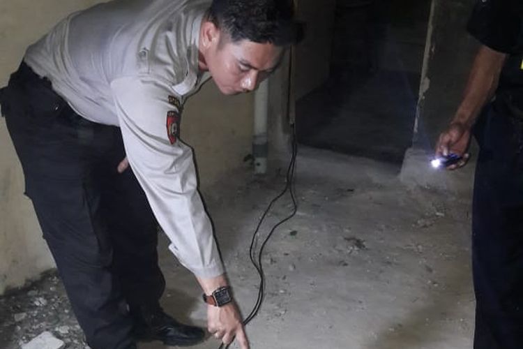 Petugas Polsek Tambang, melakukan olah TKP di lokasi remaja yang ditemukan tewas diduga akibat tersengat listrik di Desa Kualu, Kecamatan Tambang, Kabupaten Kampar, Riau, Selasa (9/4/2019). Dok. Polres Kampar