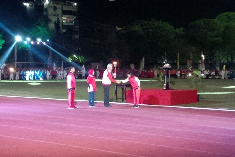 Gubernur Jateng Ganjar Pranowo didampingi istri menerima api obor dalam pembukaan Porprov Jateng XV Tahun 2018 di Stadion Sriwedari Solo, Jawa Tengah, Jumat (19/10/2018) malam.