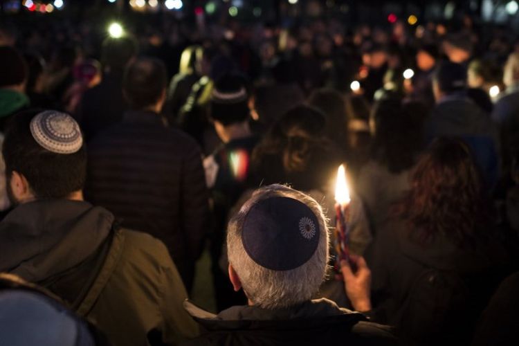 Anggota dan pendukung komunitas Yahudi menyalakan lilin untuk menghormati korban penembakan di sinagoge Tree of Life Synagogue di lingkungan Squirrel Hill di Pittsburgh. Mereka berkumpul di depan Gedung Putih di Washington DC pada Sabtu (27/10/2018). (AFP/Andrew Caballero-Reynolds)