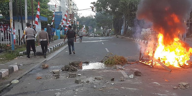 Warga pengunjuk rasa turun ke jalan dan berhadapan dengan aparat keamanan di Manokwari, Papua, Senin (19/8/2019). Aksi yang diwarnai kericuhan itu terjadi menyusul protes penangkapan mahasiswa Papua di sejumlah wilayah di Jawa Timur.