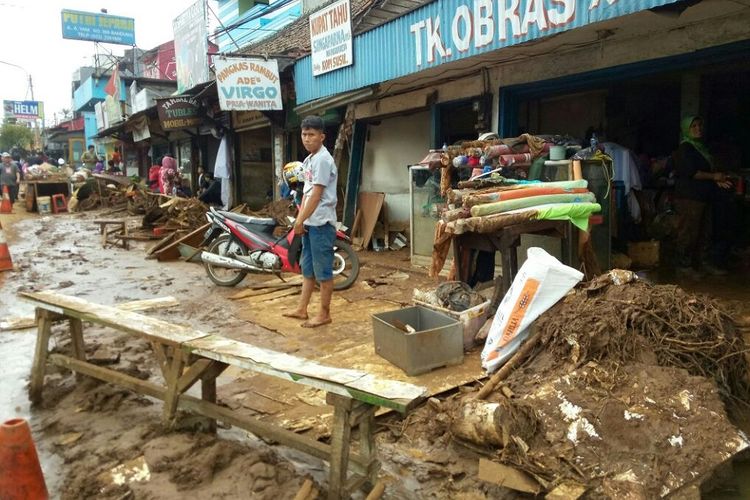 Pasca banjir bandang, para pekerja dan pemilik toko di pinggir Jalan AH Nasution masih sibuk membersihkan lumpur dan sampah di sekitar tokonya.