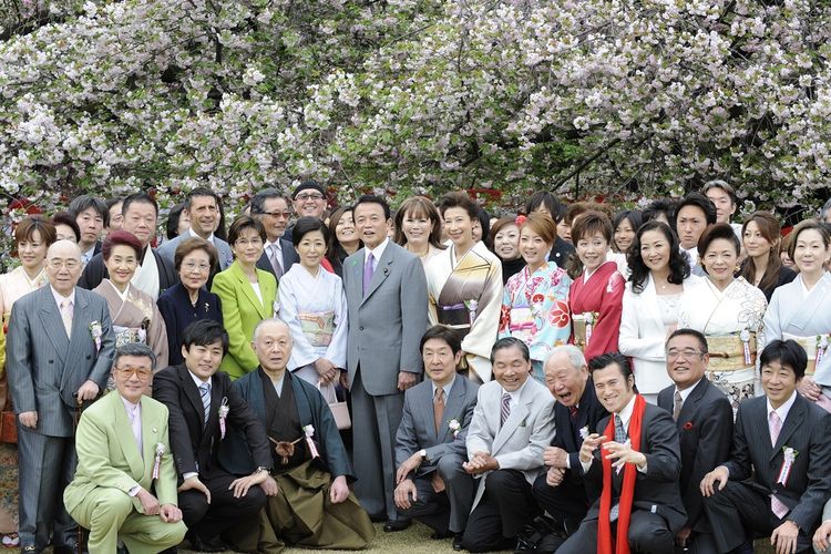 Mantan Perdana Menteri Jepang Taro Aso (tengah) berfoto bersama tamu saat perayaan tahunan Sakura di Taman Shinjuku Gyoen, Tokyo, pada 19 April 2009.