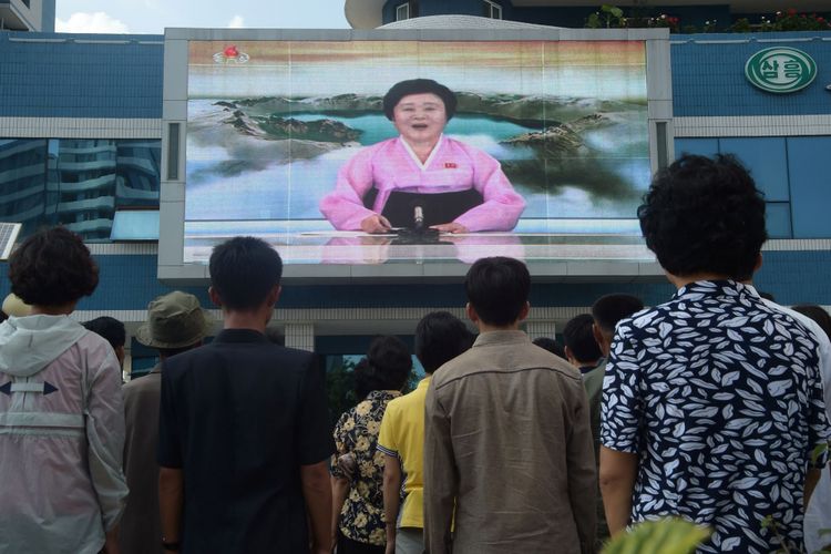 Warga menyaksikan video pada layar besar di Jalan Mirae Scientists di Pyongyang, Korea Utara, yang menampilkan pembawa acara Ri Chun-Hee mengumumkan berita bahwa negara tersebut berhasil menguji coba bom hidrogen pada Minggu (3/9/2017).