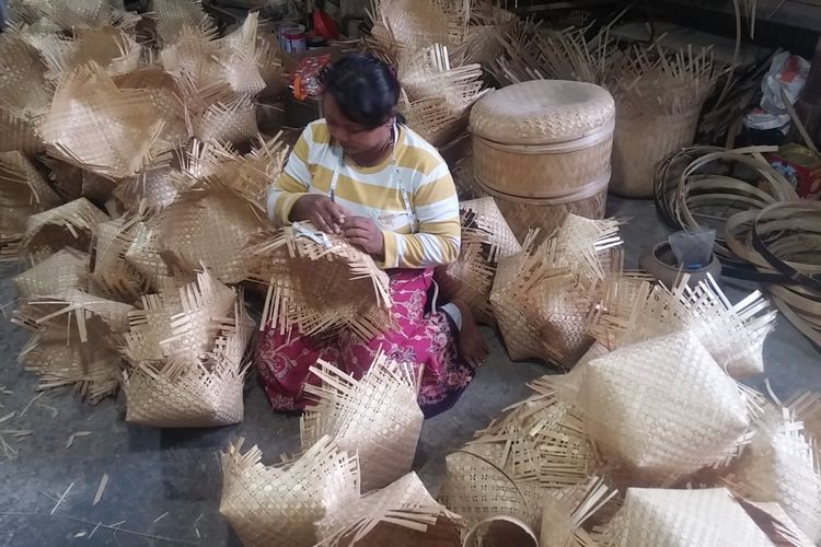 Perajin Bambu Indah Craft Trenggalek sedang menganyam bambu untuk dibuat produk keranjang.