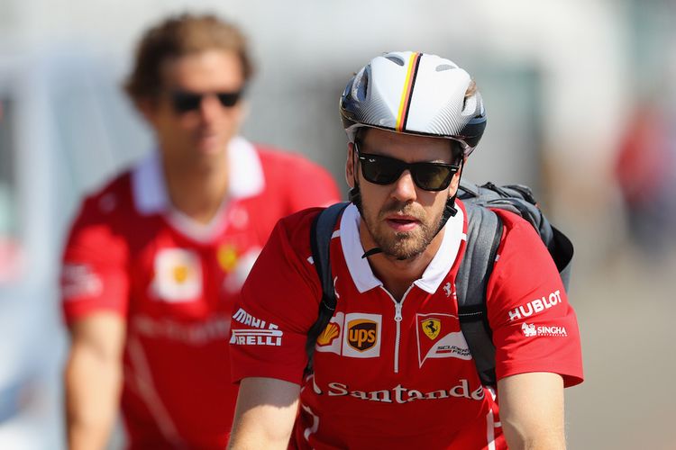 Pebalap Ferrari asal Jerman, Sebastian Vettel, bersepeda saat tiba di Sirkuit Gilles Villeneuve jelang balapan GP Kanada, Minggu (11/6/2017).