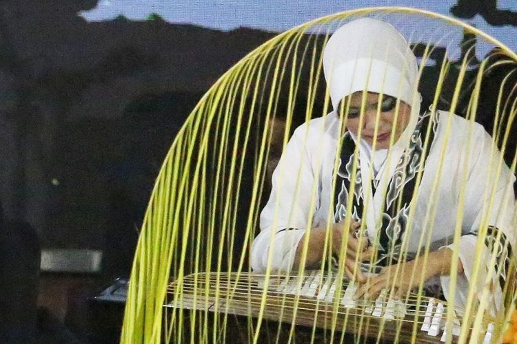 Siska Amelia, seorang seniman katolik saat memetik Ku Cheng, alat musik tradisional China, pada perayaan Maulid Nabi Muhammad SAW di Purwakarta, Senin (19/11/2018) malam.