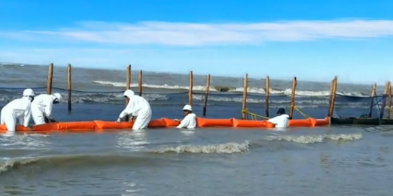 Petugas memasang oilboom shore line unutk menangkap tumpahan minyak yang terbawa hingga ke pantai  utara Pulau Jawa 