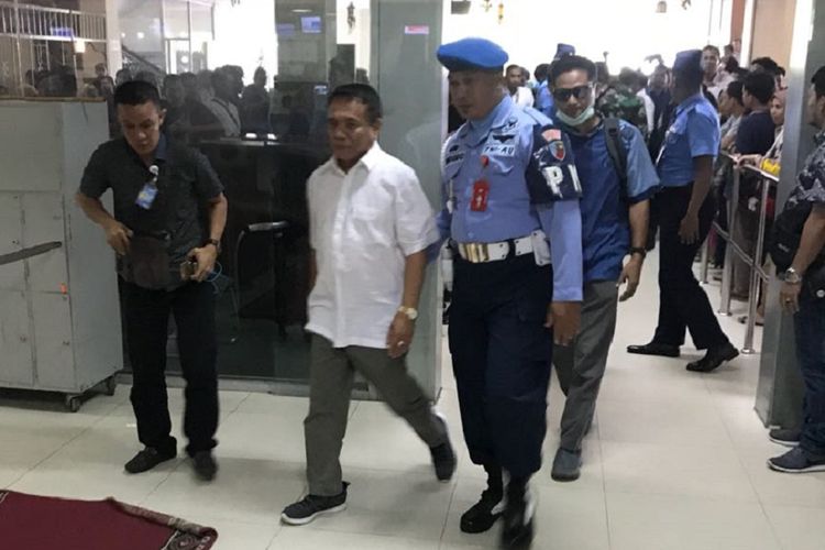 Dengan pengawalan ketat dari petugas keamanan, Gubernur aceh Irwandi Yusuf dibawa ke Jakarta, Kamis pagi (4/7/2018). Ia menggunakan penerbangan komersil Garuda indonesia dari Bandara Internasional Sultan Iskandar Muda, Aceh Besar.(KOMPAS.com/Daspriani Yuli Zamzami) 
