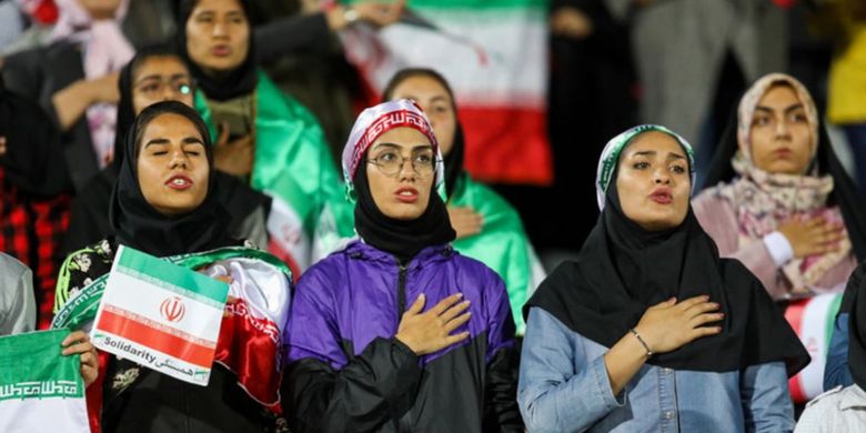 Fans perempuan Iran menyanyikan lagu kebangsaan saat tim nasional Iran beruji coba dengan Bolivia di Stadion Azadi Teheran, Selasa (16/10/2018).