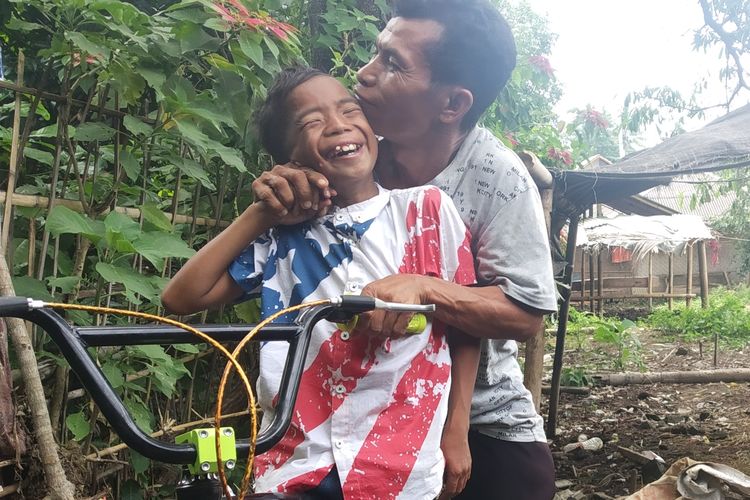 Taufik, saat bermain sepeda bersama pamannya di depan rumah, Kamis (25/4/2019).