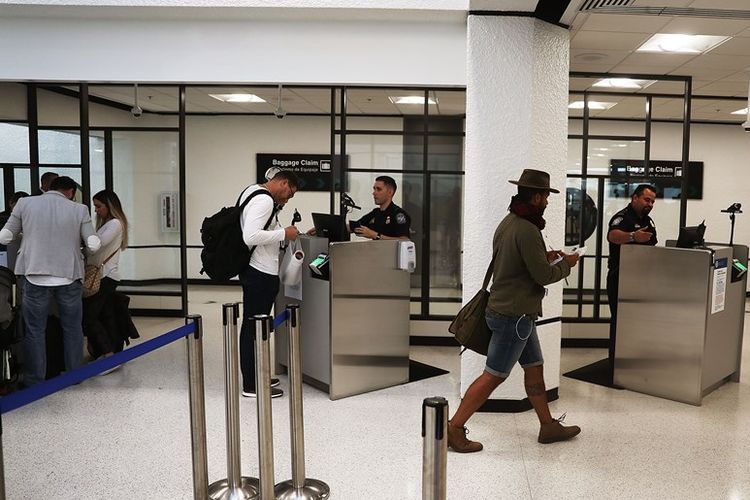 Turis saat melewati pemeriksaan Bea Cukai di bandara internasional Miami sebelum memasuki wilayah AS. Nantinya para pengunjung dan calon imigran yang akan masuk wilayah AS juga akan diwajibkan melaporkan akun media sosial mereka.