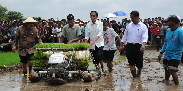 Presiden Jokowi bersama Menteri Pertanian Andi Amran Sulaiman mencoba menggunakan alsintan untuk menanam benih padi.