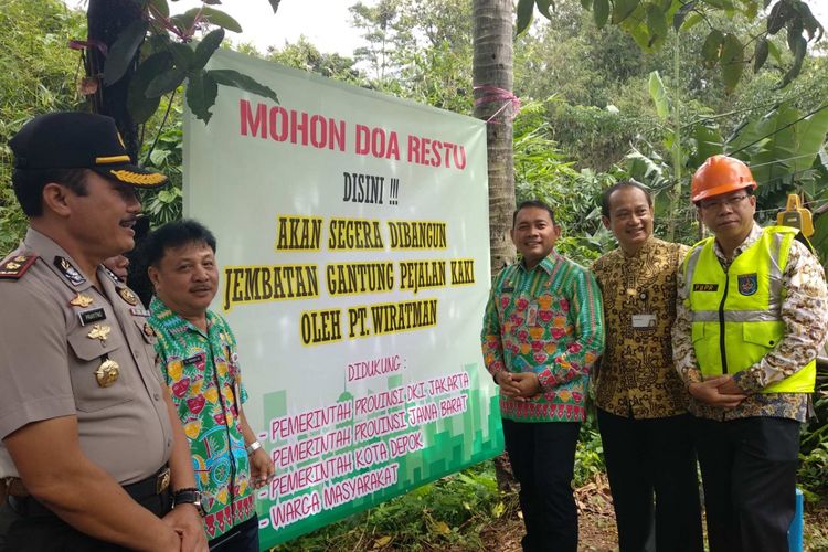 Pemasangan spanduk pemberitahuan pembangunan jembatan gantung baru di Srengseng Sawah, Jagakarsa, Kamis (25/1/2018).