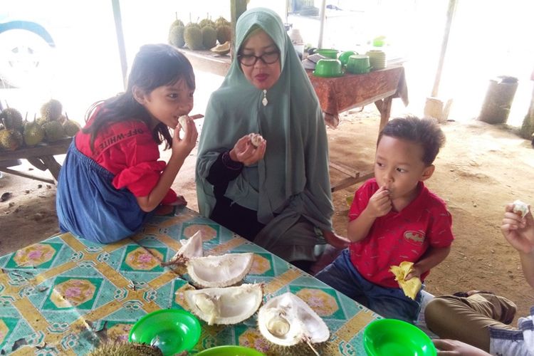 Pembeli sedang makan durian dan lemang di Desa Mendumpang, Kecamatan Suro, Kabupaten Aceh Singkil