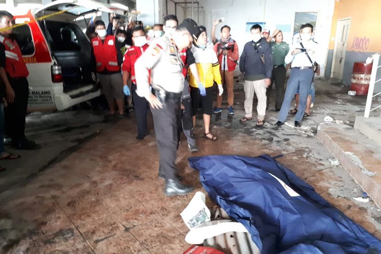 Polisi saat mengevakuasi potongan tubuh seorang wanita yang ditemukan di area parkir lantai 2 Pasar Besar Kota Malang, Selasa (14/5/2019)