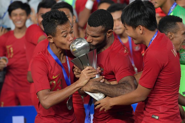 Pemain Timnas U-22 Sani Riski Fauzi (kiri) bersama Marinus Wanewar (tengah) mencium Piala AFF U-22 seusai penganugerahan piala di Stadion Nasional Olimpiade Phnom Penh, Kamboja, Selasa (26/2/2019). Indonesia menjadi juara setelah mengalahkan Thailand di babak final dengan skor 2-1.