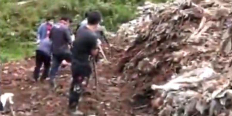 Petugas penyelamat di Zhenxiong, China, terlihat berusaha  menggali tumpukan sampah di mana dua kakak beradik tewas tertimbun pada Selasa (10/7/2018).