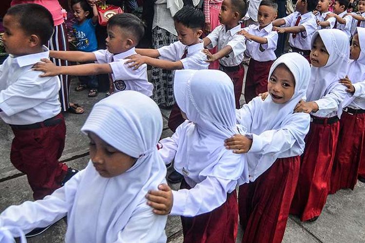 Siswa baru kelas satu Sekolah Dasar Negeri Pengadilan berbaris disaksikan para orangtua di Kota Tasikmalaya, Jawa Barat, Senin (15/7/2019). Hari pertama masuk sekolah tahun ajaran 2019-2020 dimulai serentak dan para orang tua siswa hadir mengantar anaknya untuk mengenal lingkungan sekolah serta berinteraksi dengan pihak sekolah dan guru.