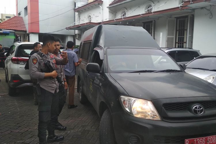 Polisi berjaga di samping mobil tahanan terdakwa kasus pembunuhan satu keluarga di Makassar saat berada di PN MAKASSAR, Kamis (4/4/2019)