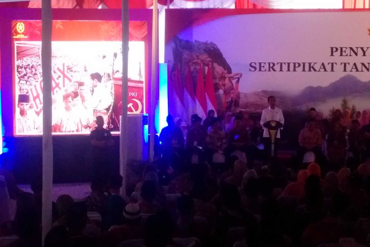 Presiden Jokowi menunjukkan sebuah gambar hoax yang menunjukkan dirinya berada didekat podium saat tokoh PKI DN Aidit berpidato pada acara penyerahan 2500 sertifikat di Alun-Alun Kabupaten Ponorogo, Jawa Timur, Jumat ( 4 / 1 / 2019) sore.