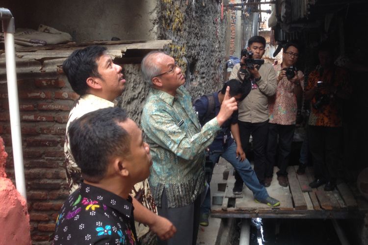 Deputi Gubernur DKI Jakarta Bidang Tata Ruang dan Lingkungan Hidup Oswar Muadzin Mungkasa (tengah) bersama Lurah Duri Utara Denny Aputra saat memantau kondisi tangki septik yang telah dibangun di sekitar rumah warga, Duri Utara, Tambora, Jakarta Barat, Jumat (25/5/2017).