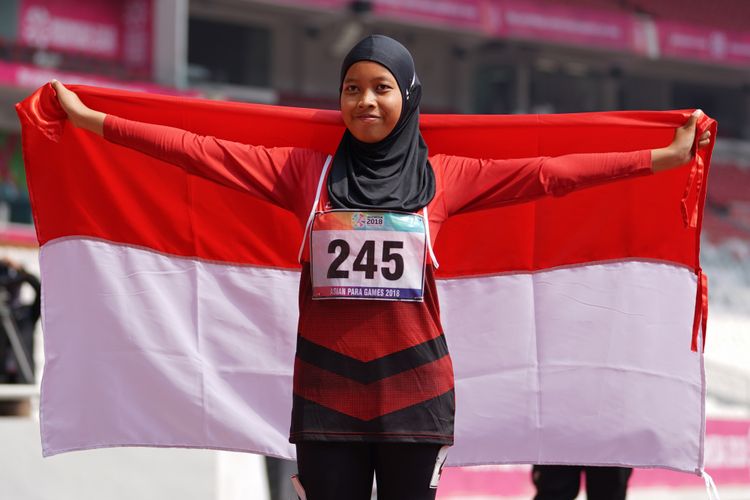 Tiarani Karisma Evi melakukan selebrasi bendera setelah memenangkaan lomba nomor 100m Women T42, T63 pada Asian Para Games 2018, distadion Utama Gelora Bung Karno , Jakarta,  Rabu (10/10/2018)