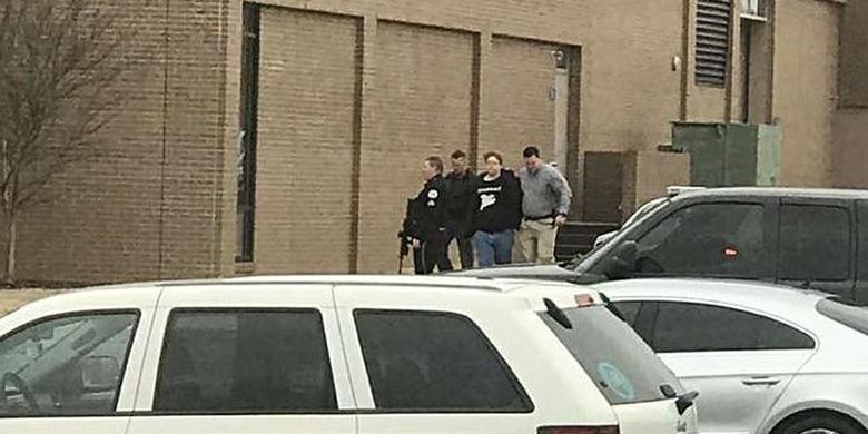 Polisi mengamankan seseorang (kedua dari kanan), keluar dari SMA Marshall County, setelah melakukan penembakan di sekolah tersebut pada Selasa (23/1/2018), di Benton, Kentucky, Amerika Serikat.