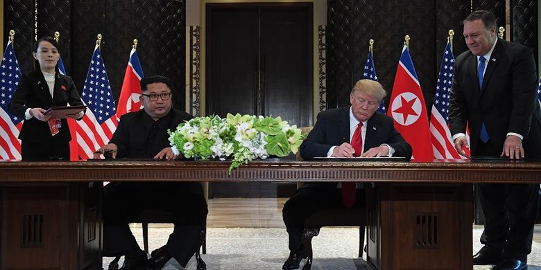 Presiden AS Donald Trump dan pemimpin Korea Utara Kim Jong Un menandatangani kesepakatan usai melakukan pertemuan di Hotel Capella, Singapura, Selasa (12/6/2018). Penandatanganan ini disaksikan Menlu AS Mike Pompeo dan adik Kim Jong Un, Kim Yo Jong.
