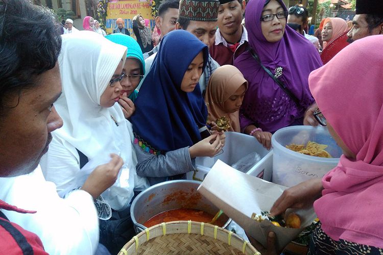 Para pengunjung saat berebut sajian gratis dalam Festival Sego Boranan, di Lamongan, Jatim, Sabtu (26/5/2018).