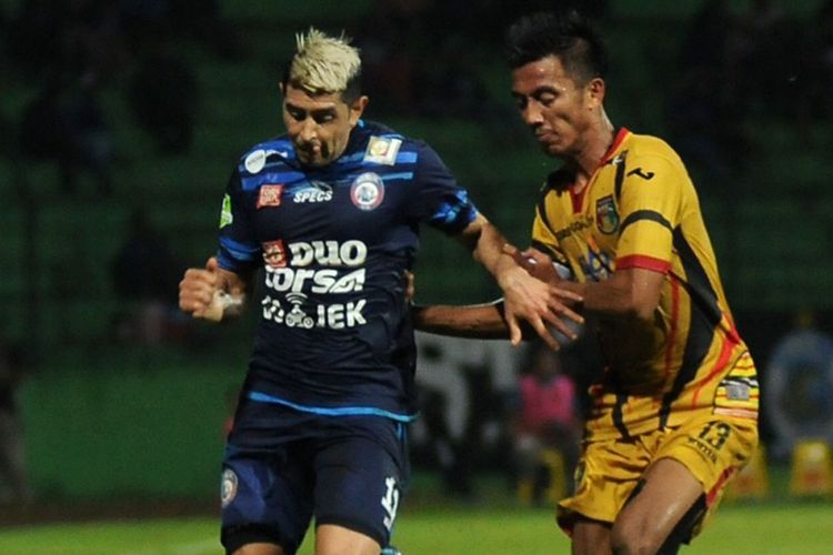 Gelandang Arema FC, Vizcarra, berduel dengan kapten Mitra Kukar, Bayu Pradana.
