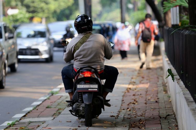 Pengendara sepeda motor yang melintasi trotoar di Jl. H. Agus Salim, Jakarta Pusat, Senin (17/7/2017). Pengendara sering memanfaatkan trotoar untuk memotong jalan agar bisa lebih cepat ketimbang melewati jalan raya.
