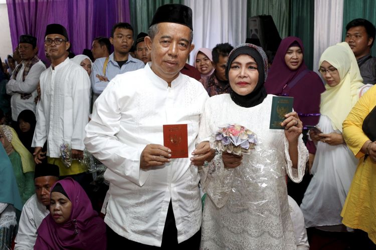 Pasangan pengantin mengikuti nikah massal yang diselenggarakan Partai Kebangkitan Bangsa di KUA Menteng, Jakarta Pusat, Jumat (25/8/2017). Sebanyak 103 pasangan pengantin mengikuti acara ini.