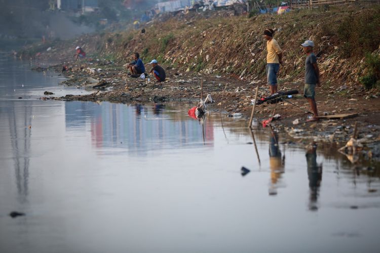 Warga memancing di Kanal Banjir Barat (KBB) sungai Ciliwung di Tanah Abang, Jakarta Pusat, Kamis (21/9/2017). Terbatasnya ruang terbuka hijau atau lahan bermain di pemukiman padat penduduk menyebabkan warga setempat memanfaatkan lahan kosong dipinggir sungai Ciliwung sebagai tempat bermain.
