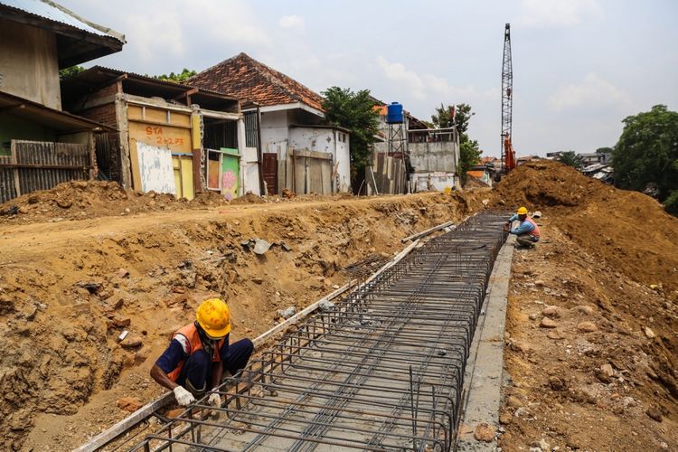 Pekerja menyelesaikan proyek normalisasi Sungai Ciliwung di kawasan Bukit Duri, Jakarta, Selasa (26/9/2017). Proyek normalisasi bantaran Sungai Ciliwung di kawasan Bukit Duri memasuki tahap pemasangan dinding turap untuk menguatkan bantaran agar tidak longsor sekaligus sebagai salah satu antisipasi banjir.