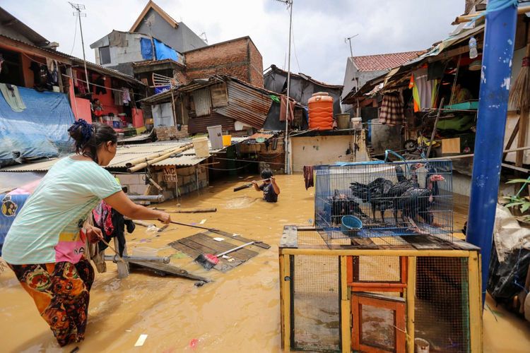 Warga beraktifitas saat banjir di Kampung Pulo, Jatinegara, Jakarta Timur, Selasa (6/2/2018). Banjir merendam ratusan rumah warga akibat luapan air dari Sungai Ciliwung.