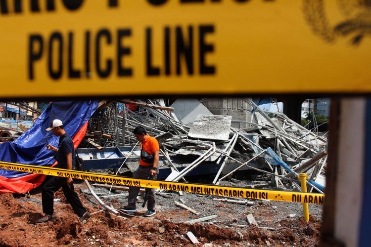 Petugas dari kepolisian mengecek kondisi pasca robohnya cetakan beton tiang pancang proyek Jalan Tol Becakayu, di Jalan DI Panjaitan, Jakarta, Selasa (20/02/2018). Peristiwa tersebut terjadi pada pukul 03.00 WIB saat pekerja sedang melakukan pengecoran. Terdapat tujuh korban yang dilarikan ke Rumah Sakit UKI dan Polri.