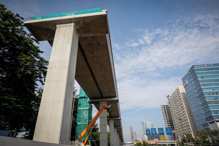 Pengendara melintas di samping lokasi pembangunan Light Rail Transit (LRT) Cawang-Pancoran di Jakarta, Sabtu (24/2/2018). Progres proyek pembangunan kereta api ringan atau Light Rail Transit (LRT) tahap I yang meliputi relasi Cibubur-Cawang, Bekasi Timur-Cawang dan Cawang-Dukuh Atas secara keseluruhan mencapai 20 persen dan ditargetkan selesai pada 2019.